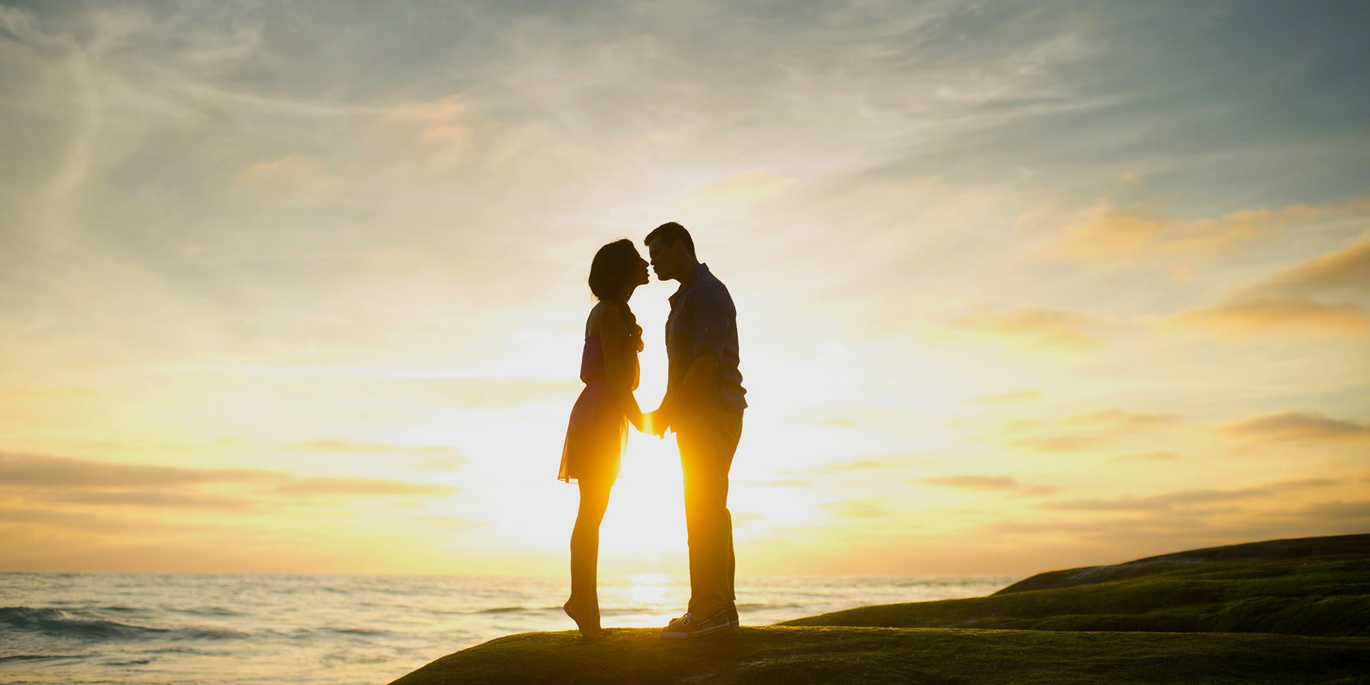 The iPhone contributed to 'a collapse in US fertility,' claims scientific study | Photo shows a couple kissing on a coastline, silhouetted against a sunset